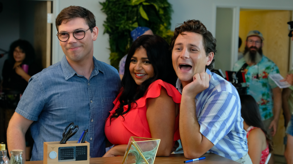 Scene from the TV show Special featuring three adults smiling and interacting at a social gathering, highlighting workplace and social dynamics involving a man with cerebral palsy.