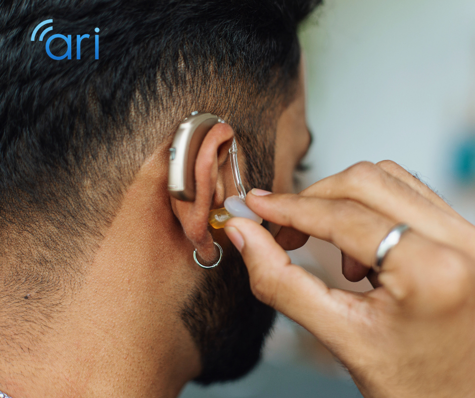 Person adjusting a behind the ear hearing aid device, illustrating assistive hearing technology used by many hard of hearing individuals.