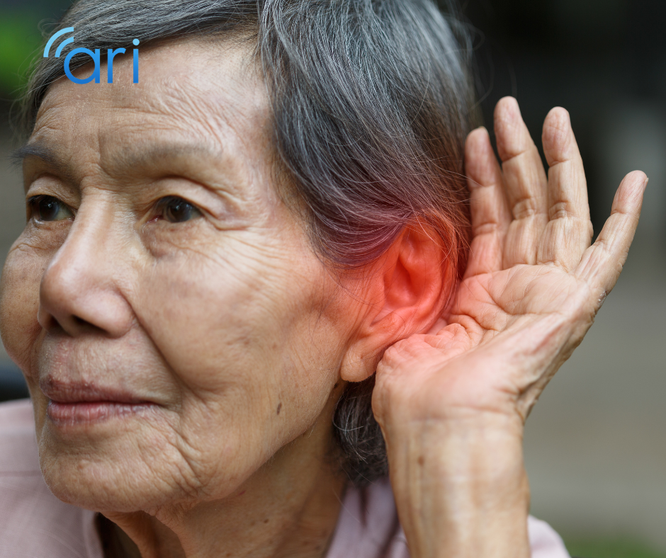 Older adult holding a hand behind the ear while listening, illustrating hearing loss and the challenges hard of hearing individuals face in everyday communication.
