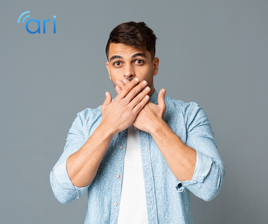 Man covering his mouth with both hands while speaking, demonstrating a common communication barrier for Deaf and hard of hearing individuals who rely on lip reading.