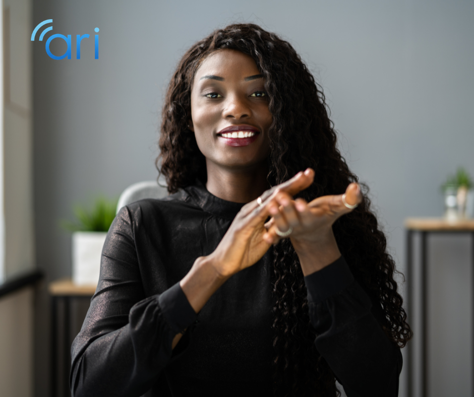 Woman signing with her hands while looking directly forward, demonstrating sign language communication used within the Deaf community.
